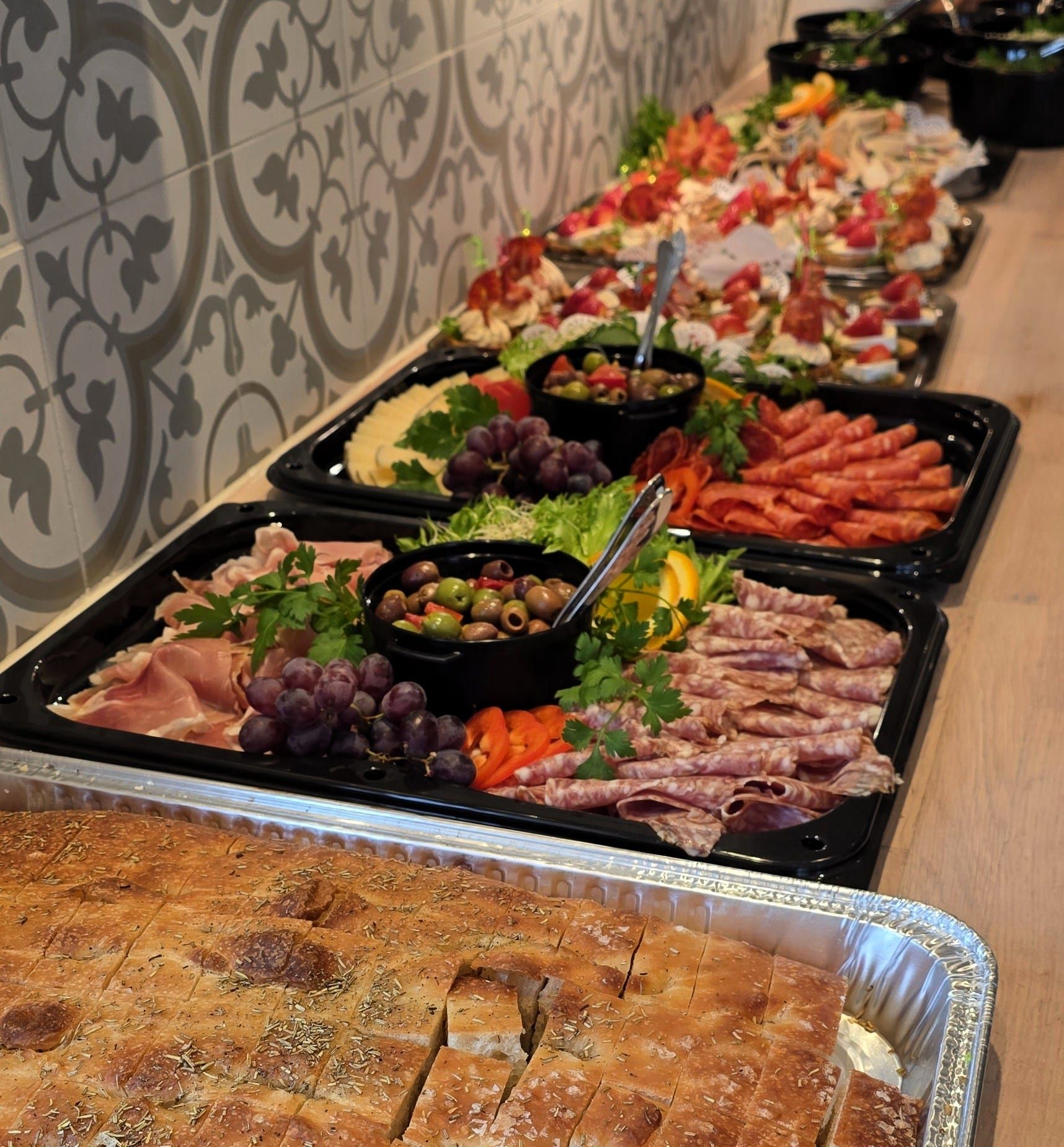 Oppdekket koldtbord og tapasbuffet med spekemat, oliven, snitter og focaccia