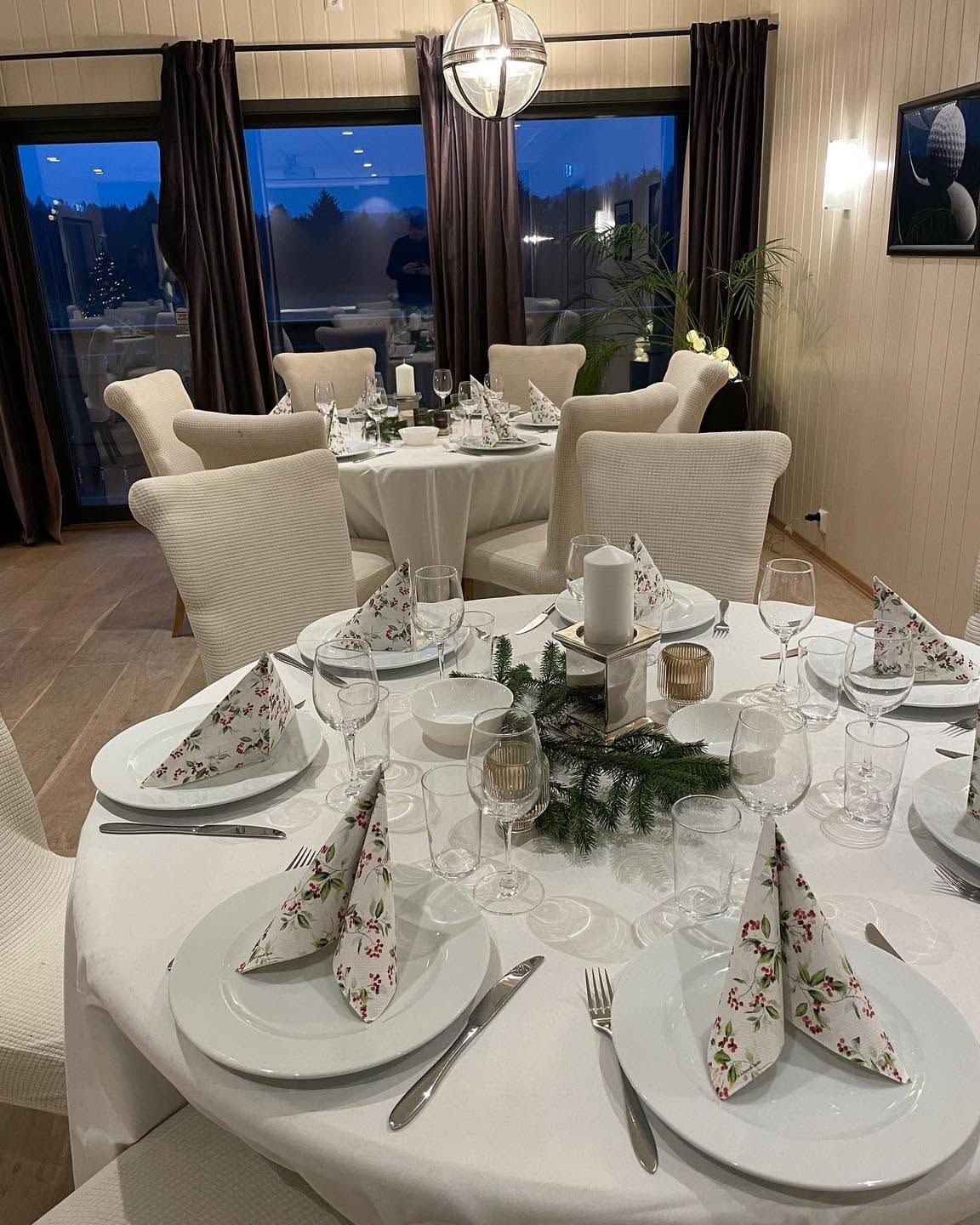 Runde bord dekket til julebord i selskapslokalet